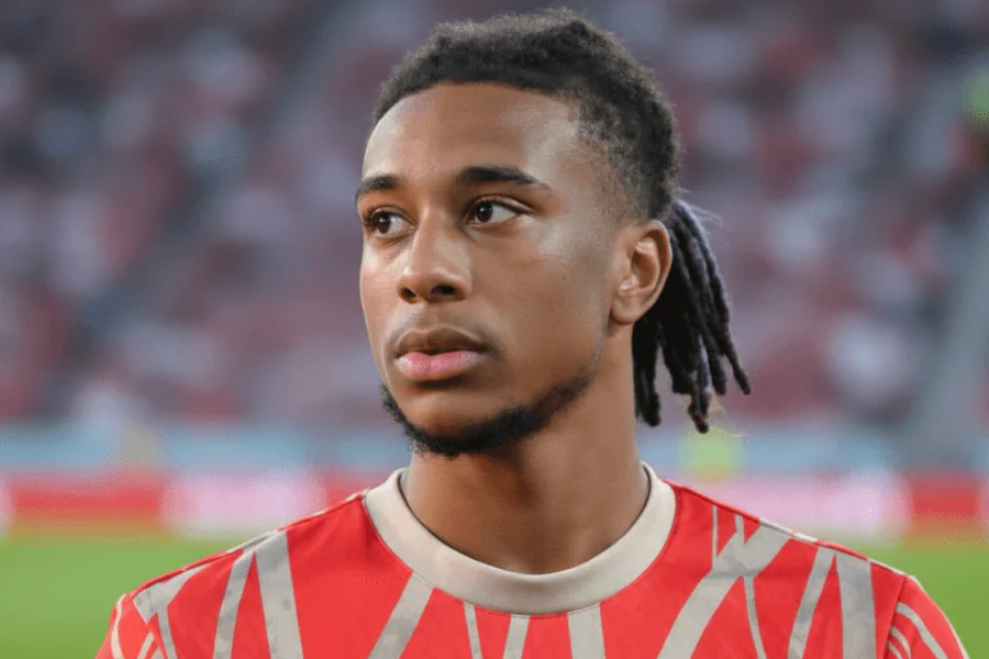 Olise dribblant un défenseur lors d'un match de Bundesliga.