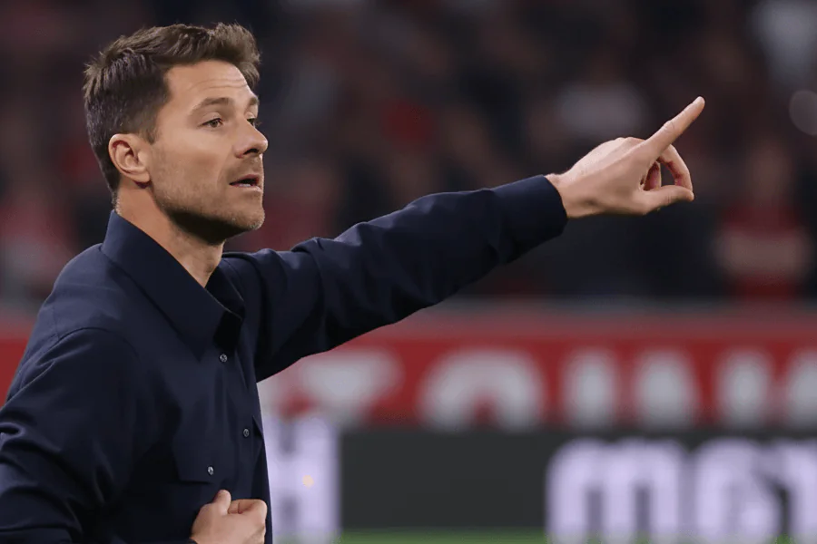 Xabi Alonso en réunion tactique sur le banc pendant un match.