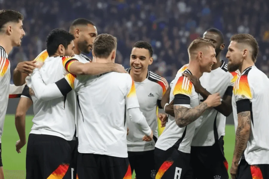 L'équipe d'Allemagne sur le terrain avec les supporters en arrière-plan.