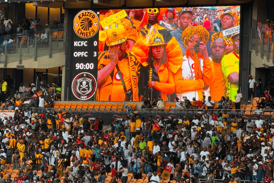Supporters d'Orlando Pirates brandissant leurs écharpes noires et blanches au FNB Stadium